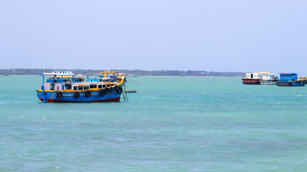 Vibrant fishing boats float on the turquoise waters of Northern Province, Sri Lanka.
