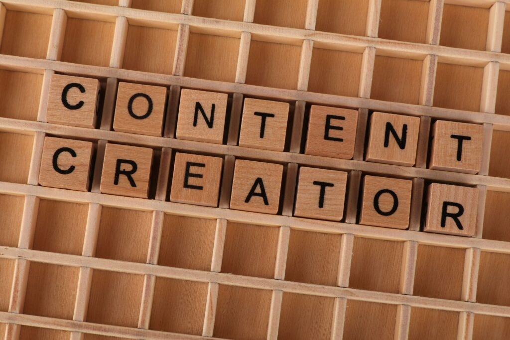 Wooden block letters spelling 'Content Creator' on a grid background. Ideal for digital marketing themes.